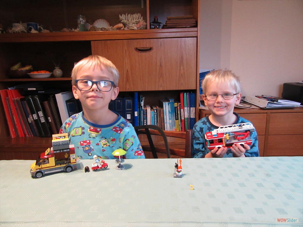 Shyly proud of a Lego pizza van and a Lego fire engine